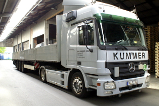 Offener Plateau-Auflieger mit Mercedes-Benz Zugmaschine in der Lagerhalle bei Spedition Paul Kummer GmbH aus Asperg bei Ludwigsburg